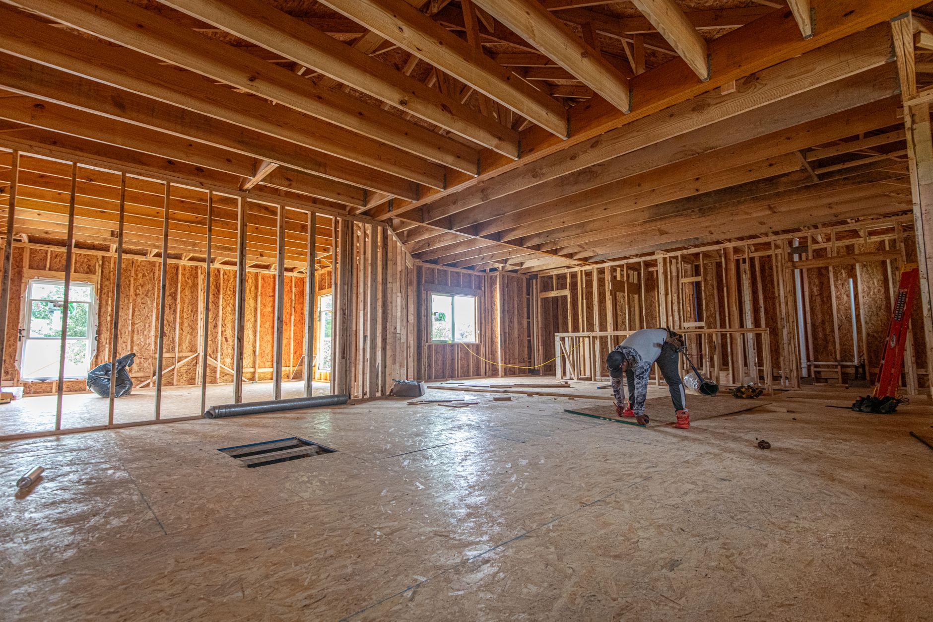 Construction crew assembling a modern new home, showcasing foundation work and framing.